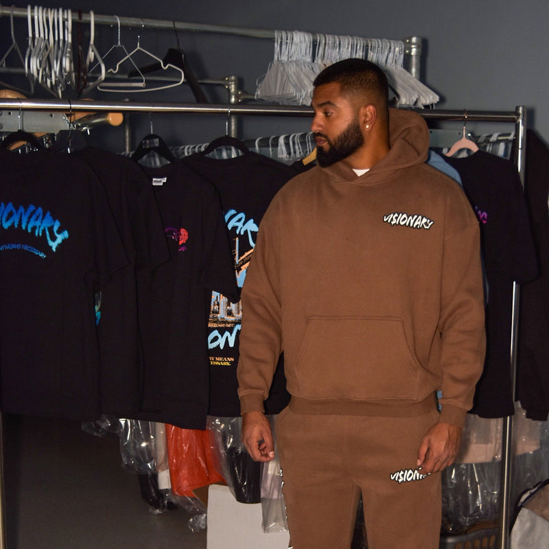 Person wearing a brown hoodie and pants in a clothing store.