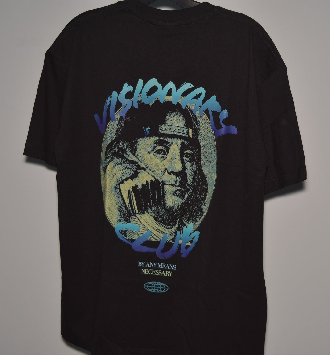 Black t-shirt with graphic design of a face holding a phone, on a plain background