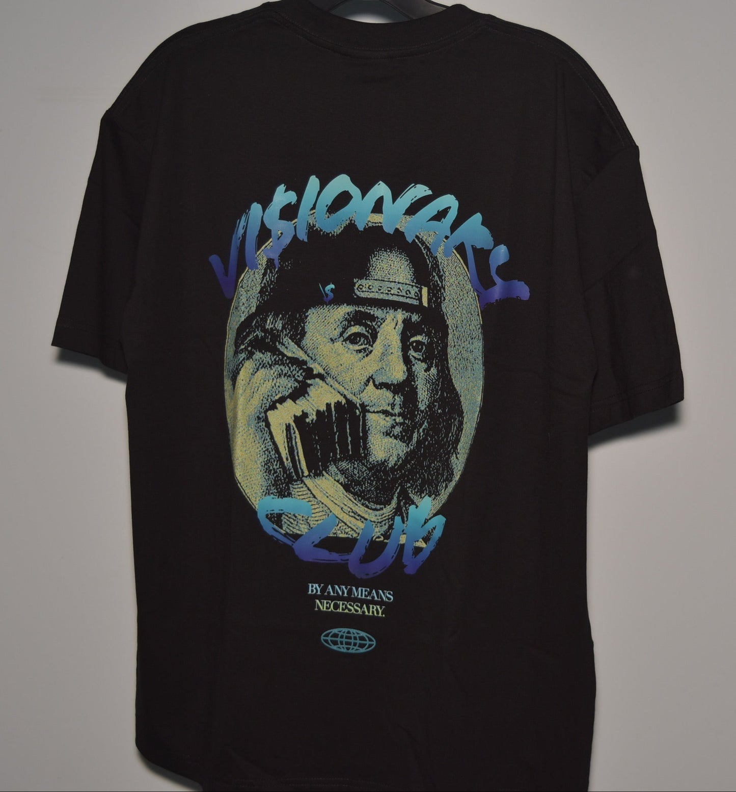 Black t-shirt with graphic design of a face holding a phone, on a plain background