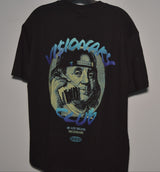 Black t-shirt with graphic design of a face holding a phone, on a plain background