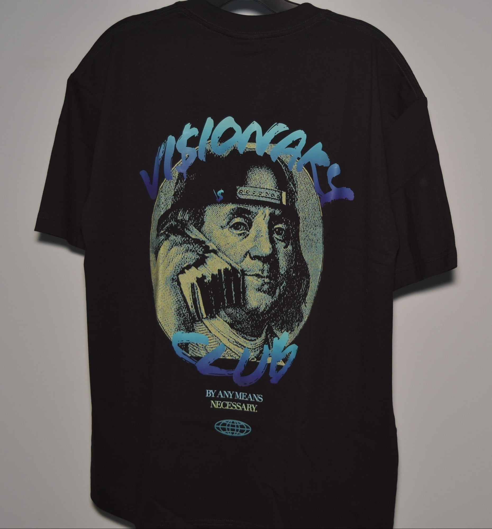 Black t-shirt with graphic design of a face holding a phone, on a plain background