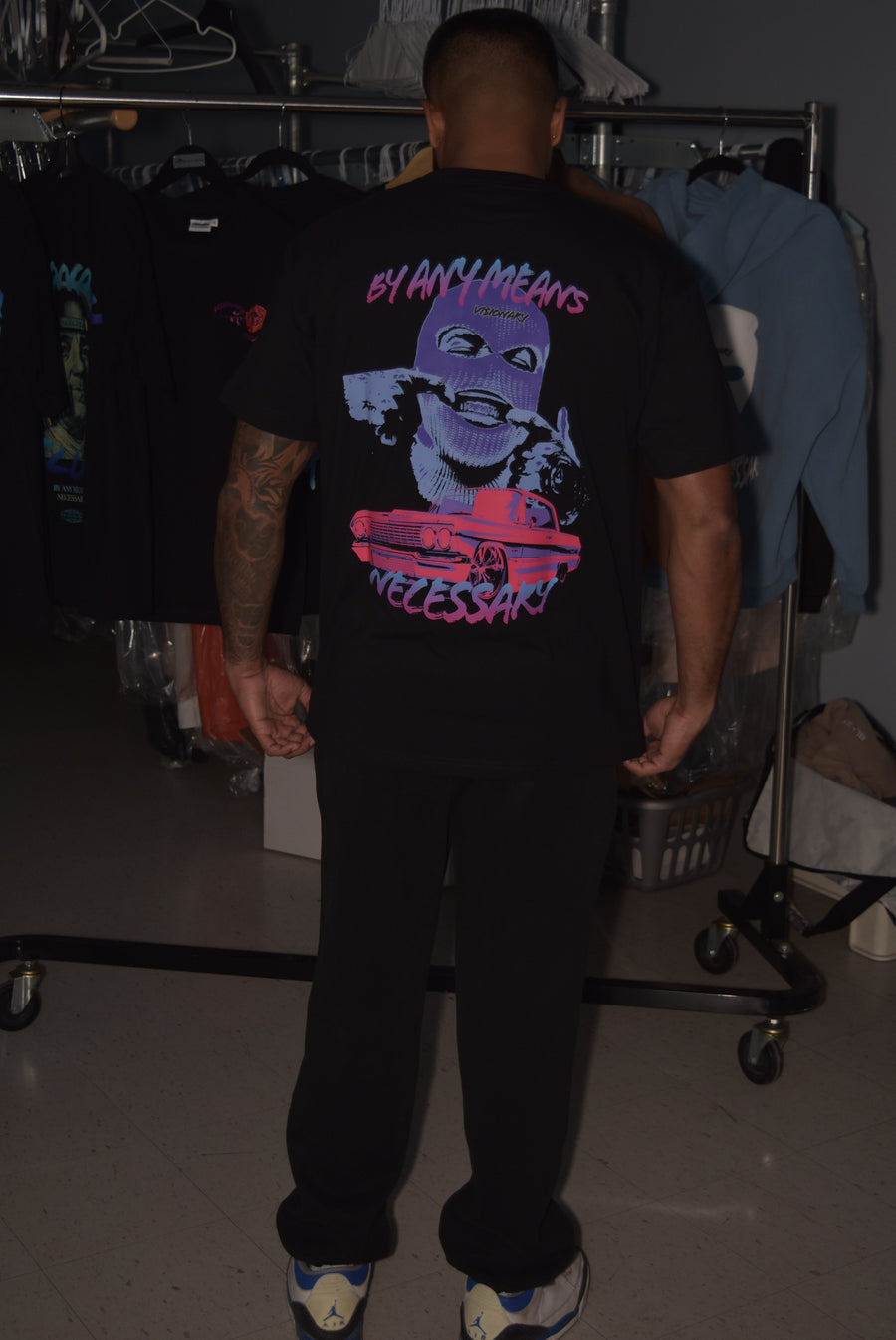 Person wearing a black t-shirt with graphic design in a clothing store.