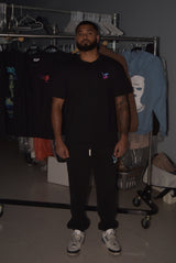 Man wearing a black t-shirt with a logo in a clothing store