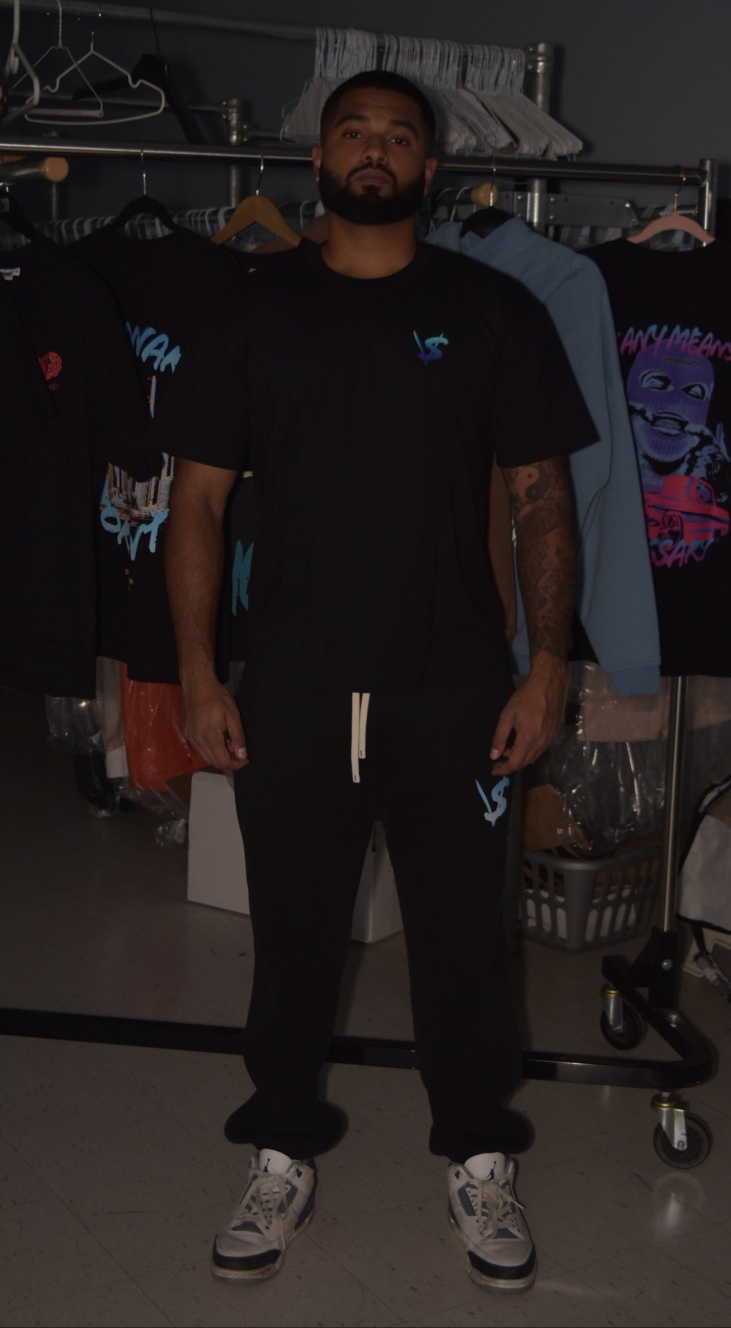 Person wearing a black t-shirt with a graphic design in a clothing store.