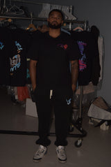 Man wearing a black t-shirt with a logo in a clothing store