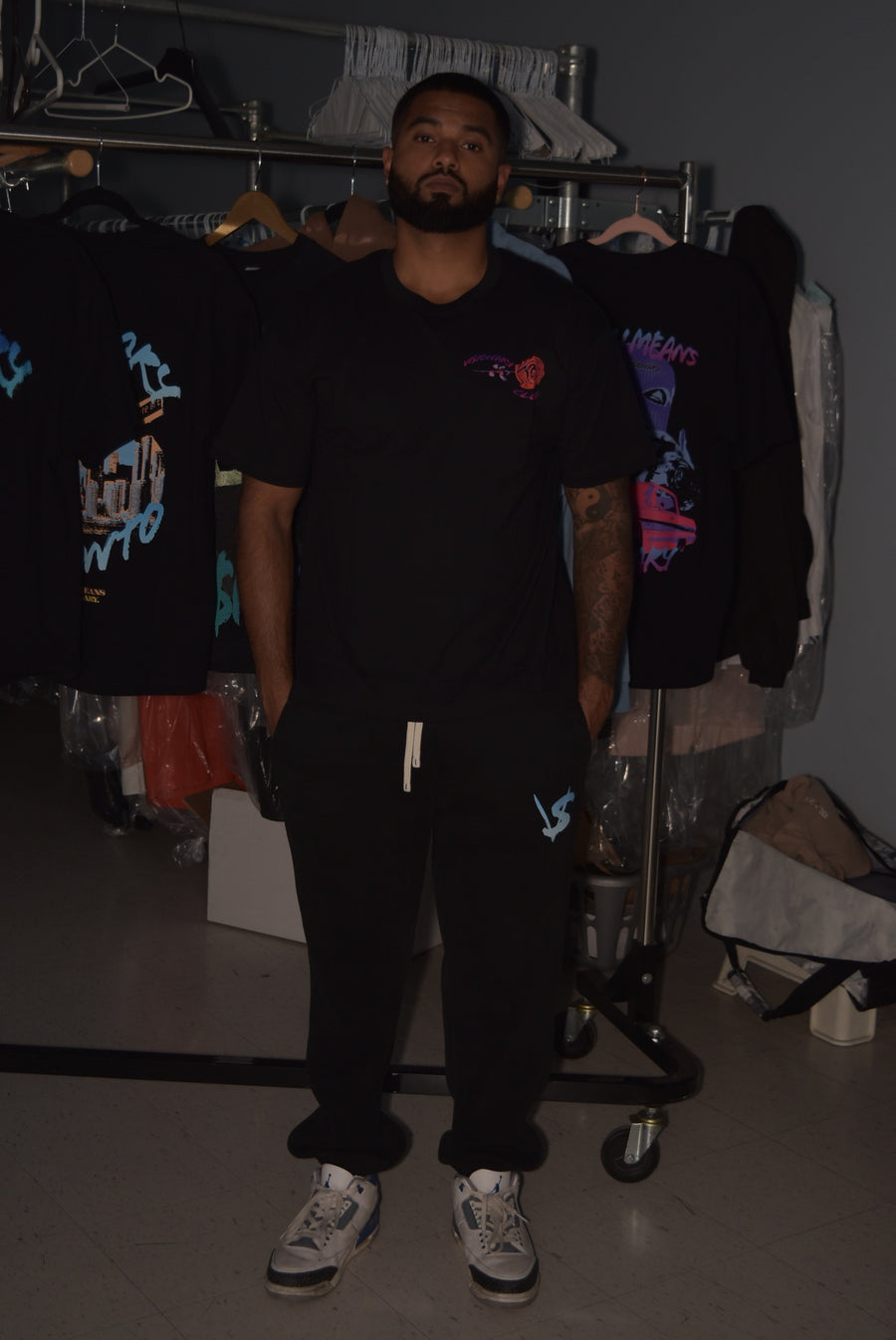 Man wearing a black t-shirt with a logo in a clothing store