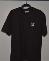 Black t-shirt with a small logo on a hanger against a plain background