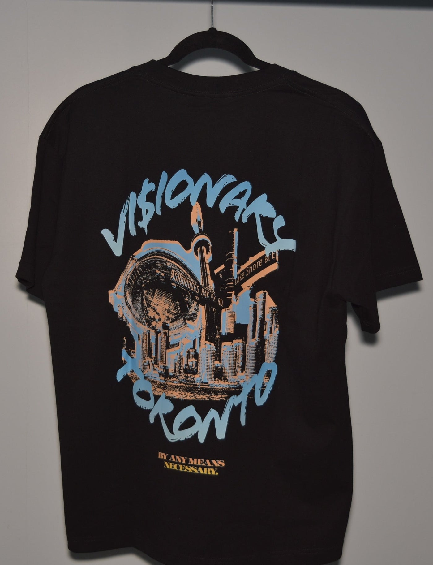 Black t-shirt with graphic design and text on a hanger against a plain background